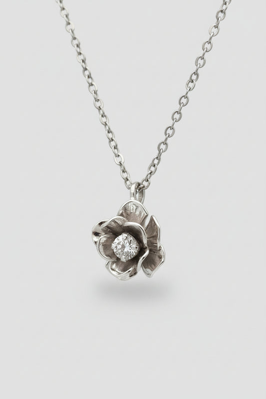 Silver flower-shaped pendant necklace on a black background