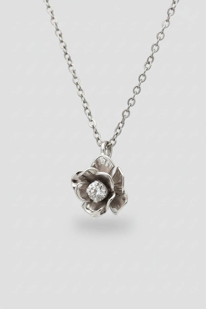 Silver flower-shaped pendant necklace on a black background