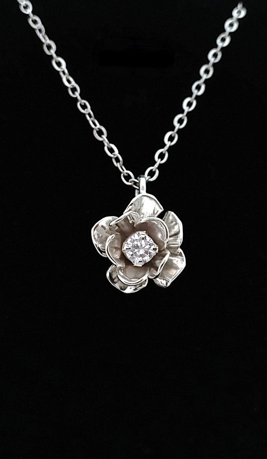 Silver flower-shaped pendant necklace on a black background