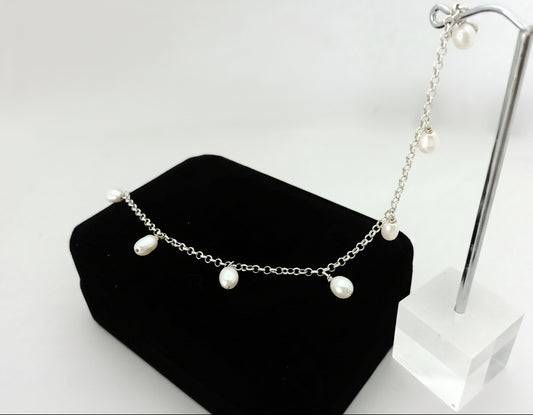 Pearl bracelet on a black jewelry display with a white background